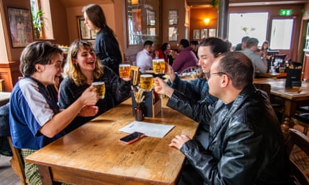 Smiling Taylor Swift fans raise glasses of beer to each other