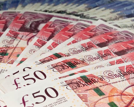a fan of new £50 notes with a fan of £20 notes in the background