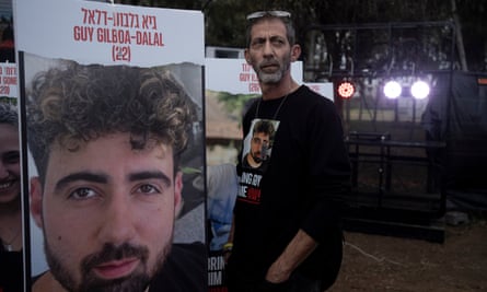 Ilan Dalal, father of Guy, stands next to a photo of his son in Re’im.