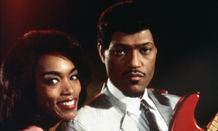 man and woman pose with a guitar