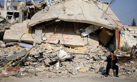 A neighbour sits near the rubble of the Abu Aweidah family’s home, destroyed in an Israeli airstrike in Rafah, southern Gaza