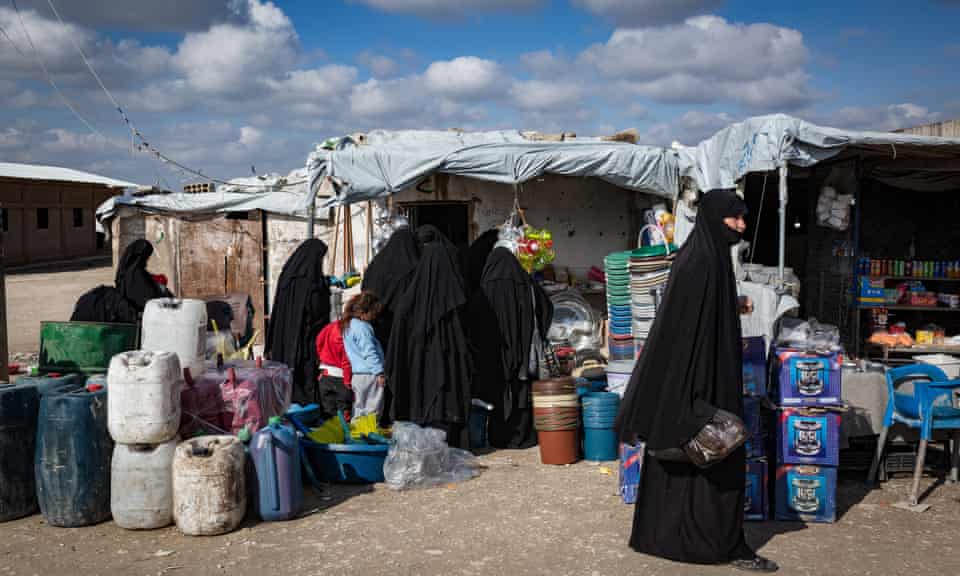 Women shop in a makeshift market inside al-Hawl camp in Syria