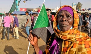 A Sudanese woman holds a national flag during a demonstration in front of the military headquarters in Khartoum