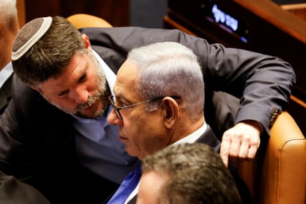 Bezalel Smotrich speaks with Benjamin Netanyahu as lawmakers gather at the Knesset to vote on a bill that would limit some supreme court power on 24 July 2023 in Jerusalem.