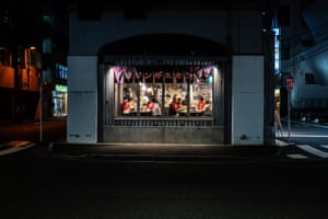 Diners in a barbecue restaurant, seen from outside through a window