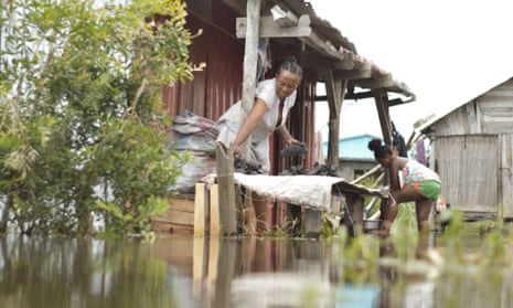 Residents of the Belle Souvenir neighborhood try to resume their daily life in their house submerged by water in Sambava on January 21, 2023, following the passage of cyclone Cheneso on January 19, 2023.