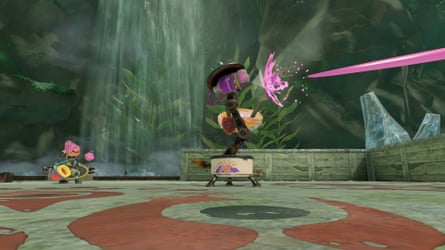 A squid kid from Splatoon Raiders is looking at a gadget that shoots pink paint into the distance.