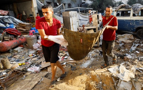 Palestinians inspect the site of an overnight Israeli strike on a tent, in Gaza City, 22 August 2025.