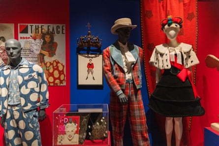 Rebel-Storyteller-Visionary retrospective exhibition, including mannequins wearing tartan suits, blue spotted costumes and crowns and puffball dresses, with enlargements of 80s fashion magazines on the walls and within glass cases