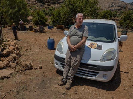 Hamze leans against his small white van parked at the shelter