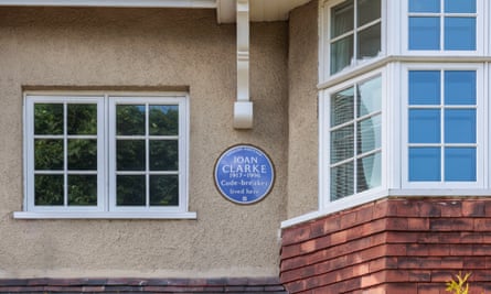 Close up of a 1930s-style house with a blue plaque on the upper storey by a bay window