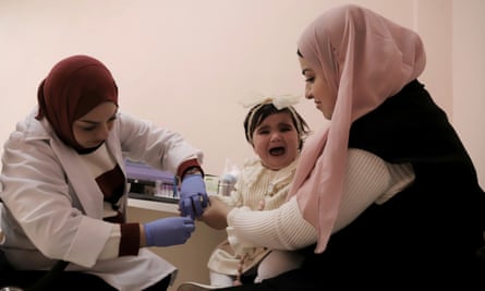 A medic with a woman and child at the clinic
