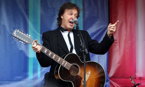 Sir Paul McCartney on stage with a guitar