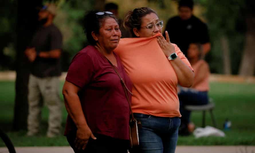 Two women are emotional as they stand outside.