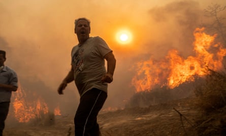 Temmuz ayında Yunanistan'ın Rodos kentinde bir yangınla çevrili bir adam