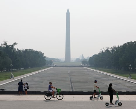 People cycle past the drained reflecting pool, as seen on Friday.