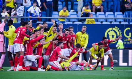 Las Palmas players celebrate Las Liga survival on the pitch.