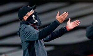 Jürgen Klopp gesturing on the touchline while wearing a mask