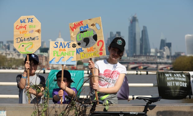 Young protesters hold placards on Waterloo Bridge on Sunday