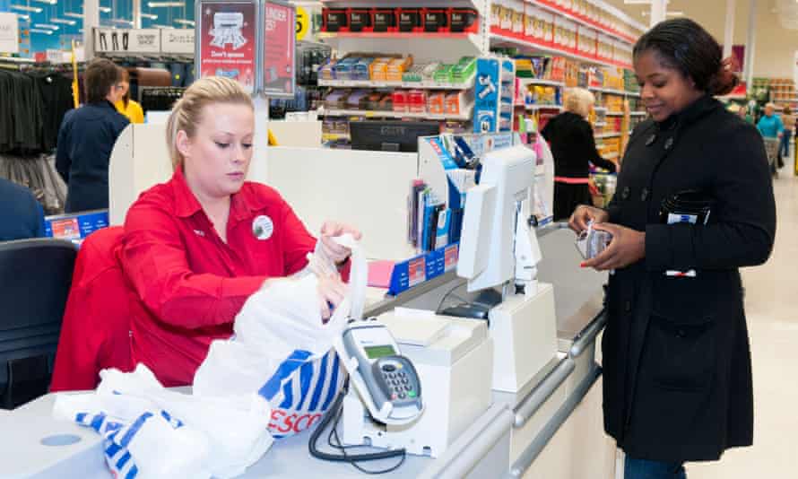 Customer is served at the till in a Tesco store