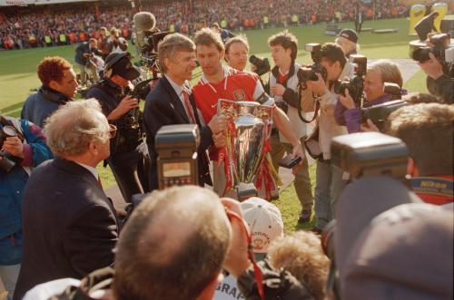 Wenger holds the Premier League trophy with Arsenal captain Tony Adams.