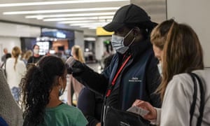 Passengers are screened for fever prior to boarding a Delta flight from JFK International Airport to Tel Aviv.