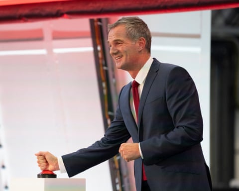 Peter Kyle pressing a red button a podium