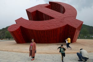 Visitors arrive at a giant emblem of the Communist Party in Nanniwan, a former revolutionary base of the party