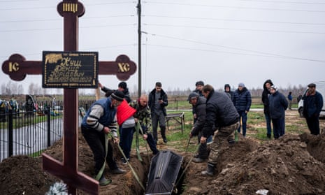 Cemetery workers dig graves and bury civilians who were killed during the Russian attacks in Bucha, Ukraine.