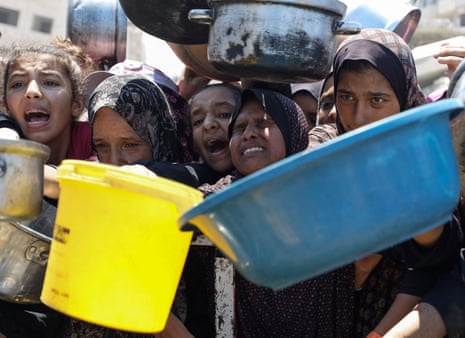 Palestinians wait to receive food from a charity kitchen, amid a hunger crisis, in Gaza City, July 24, 2025.