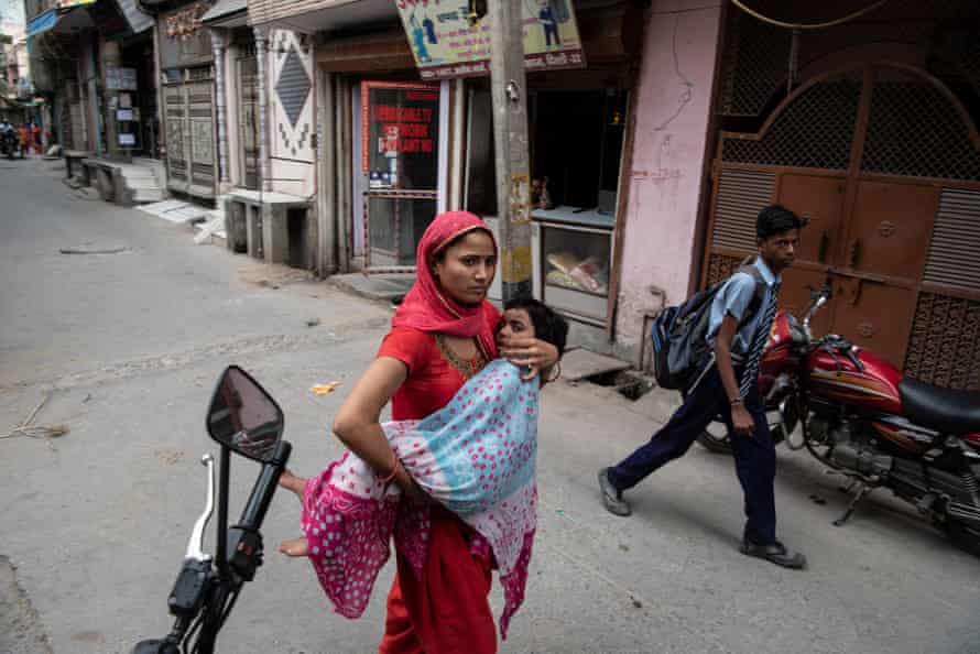 A woman carries a child to Sagar clinic.