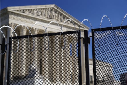The supreme court building in Washington DC is surrounded by fences and barbed wire.