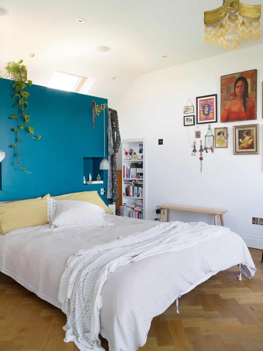 In the bedroom, a partion wall does double duty as headboard and clothes storage.