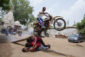 Ahmedabad, India. People practise a bike stunt before a procession marking Rath Yatra, the annual festival to the Hindu god Jagannath