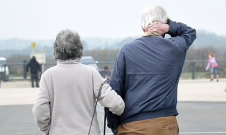 A retired older couple walking arm in arm