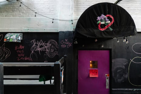 A purple door with a mask-reminder sign outside Last Ditch Bar, a mask-mandatory lesbian venue