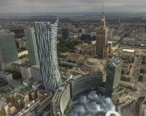 Aerial view of Warsaw's skyline, with modern towers surrounding the historic Palace of Culture