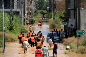 People wading through flood water being rescued