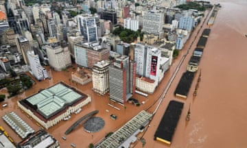 A drone view shows brown water surrounding multi-storey buildings