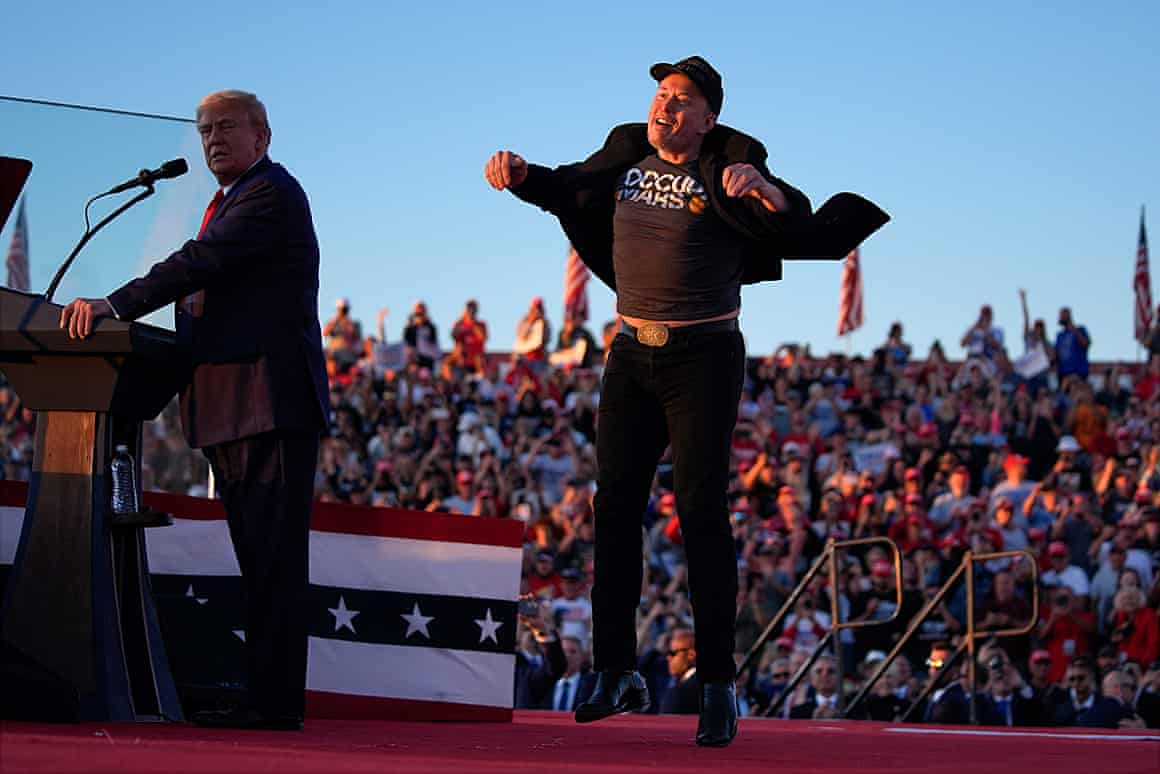 Elon Musk jumps on the stage as Donald Trump speaks at a campaign rally, 5 October.