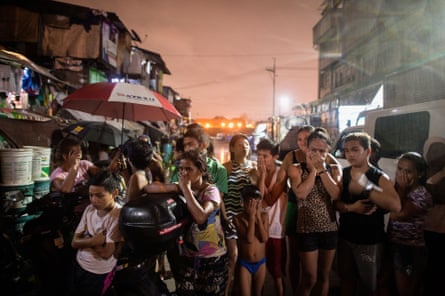 Residents react near a crime scene where three alleged drug dealers were killed after a drug raid in a shanty community in Manila.