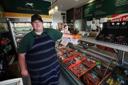 Butcher David Parsons gestures toward a meat display case in his shop