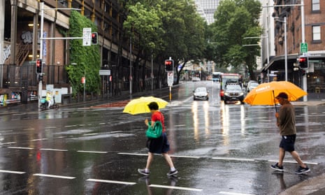 Commuters keep dry under their umbrellas.