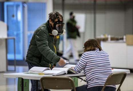 Robert Forrestal, left, wears a full face chemical shield to protect against the spread of coronavirus, as he votes at the Janesville Mall in Janesville, Wisconsin. 
