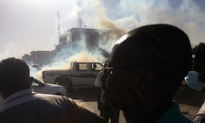 A pick-up truck drives past tear gas fired to disperse demonstrators during a protest demanding president Omar Al-Bashir in Khartoum.