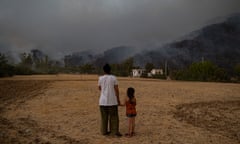 A woman and a girl hold hands while watching wildfires burning in Köyceğiz district in Turkey in 2021.
