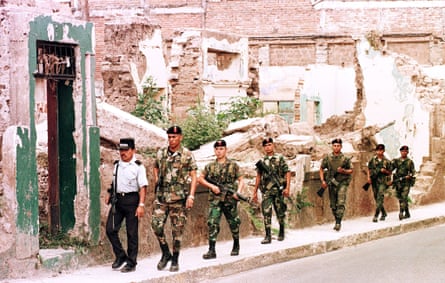 police and soldiers talk on a street