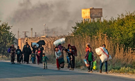 Civilians flee with their belongings amid Turkish bombardment of Ras al-Ayn.
