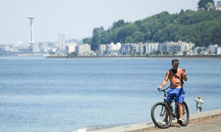 A cyclist rides along the seashore during record-breaking temperatures in Seattle, Washington.
