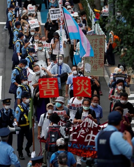 Demonstrators wearing face masks hold signs to protest against the Tokyo 2020 Olympic Games a year before the start of the summer games that have been postponed to 2021 due to the coronavirus outbreak, near National Stadium in Tokyo, Japan on Friday.